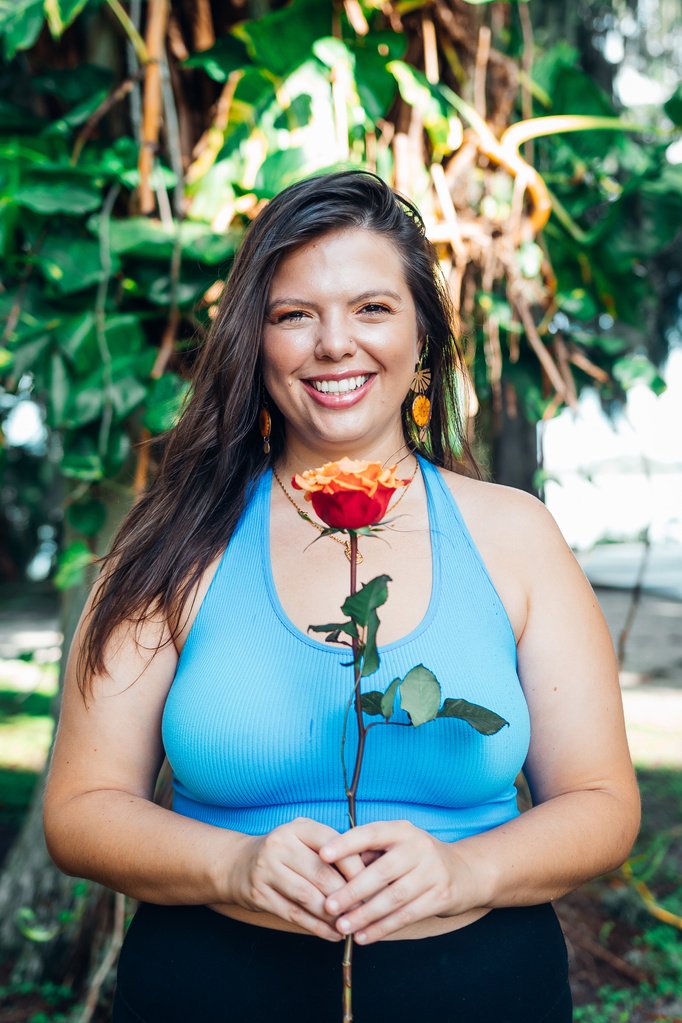 Mandy Roux holding a single red rose, a warm welcome to reach out