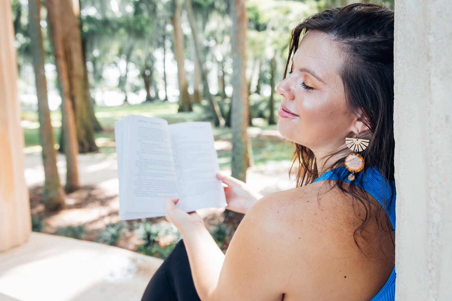 Mandy reading beneath tall Florida trees, learning the nervous system from the inside