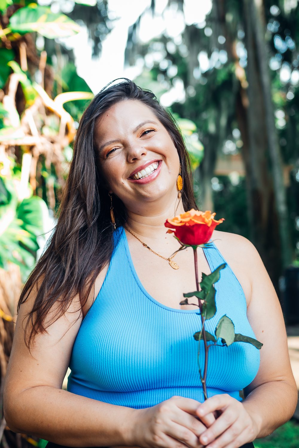 Mandy Roux, somatic therapist based in Orlando, laughing with a rose